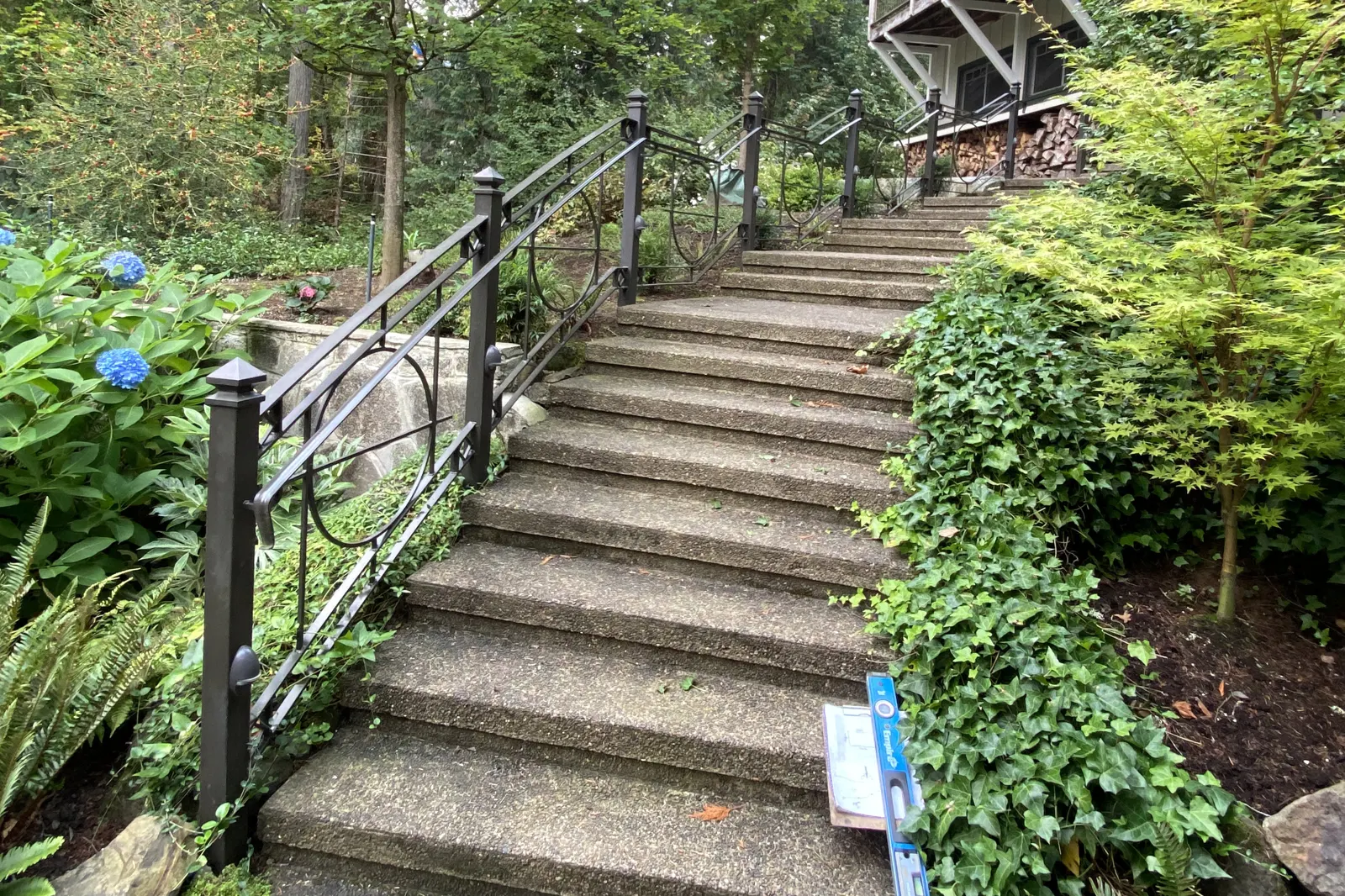 A exterior railing system with black wrought iron with a unique circular geometric scrollwork design.