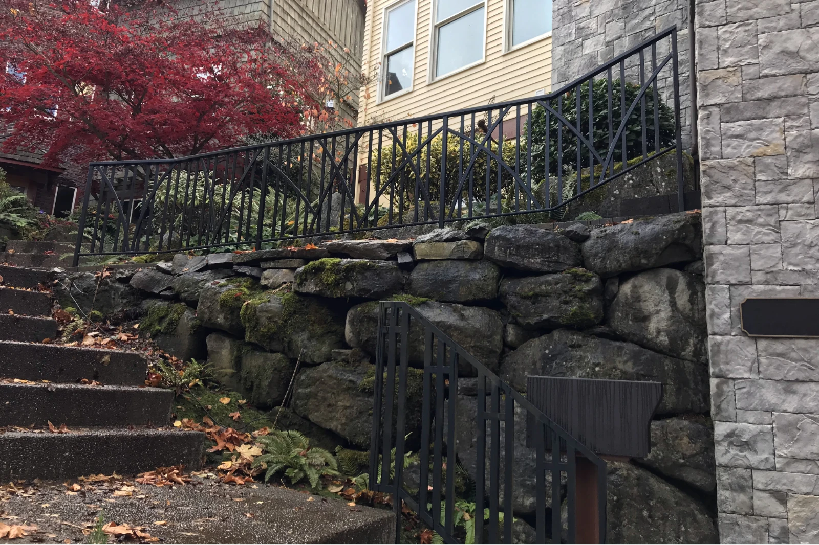 Custom-fabricated black wrought iron staircase railing featuring a decorative Gothic arch and vertical picket design.