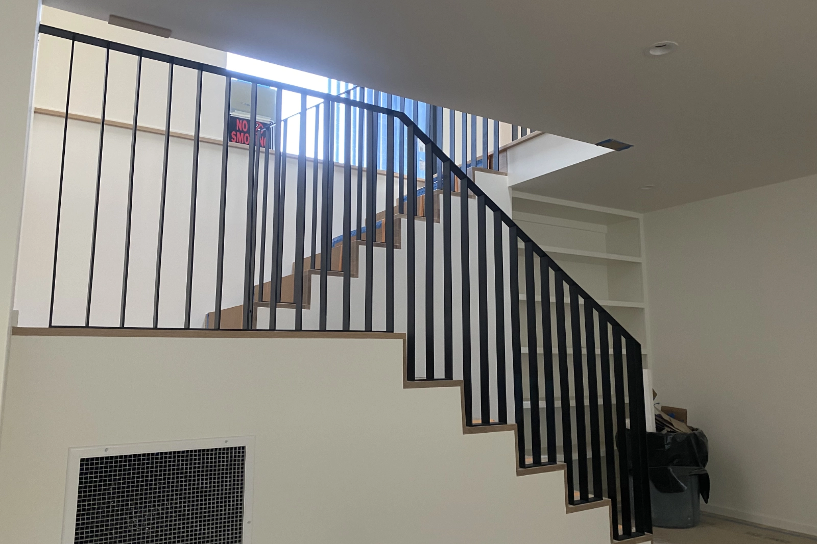 Custom-fabricated matte black residential stair railing featuring modern vertical balusters and a continuous handrail.