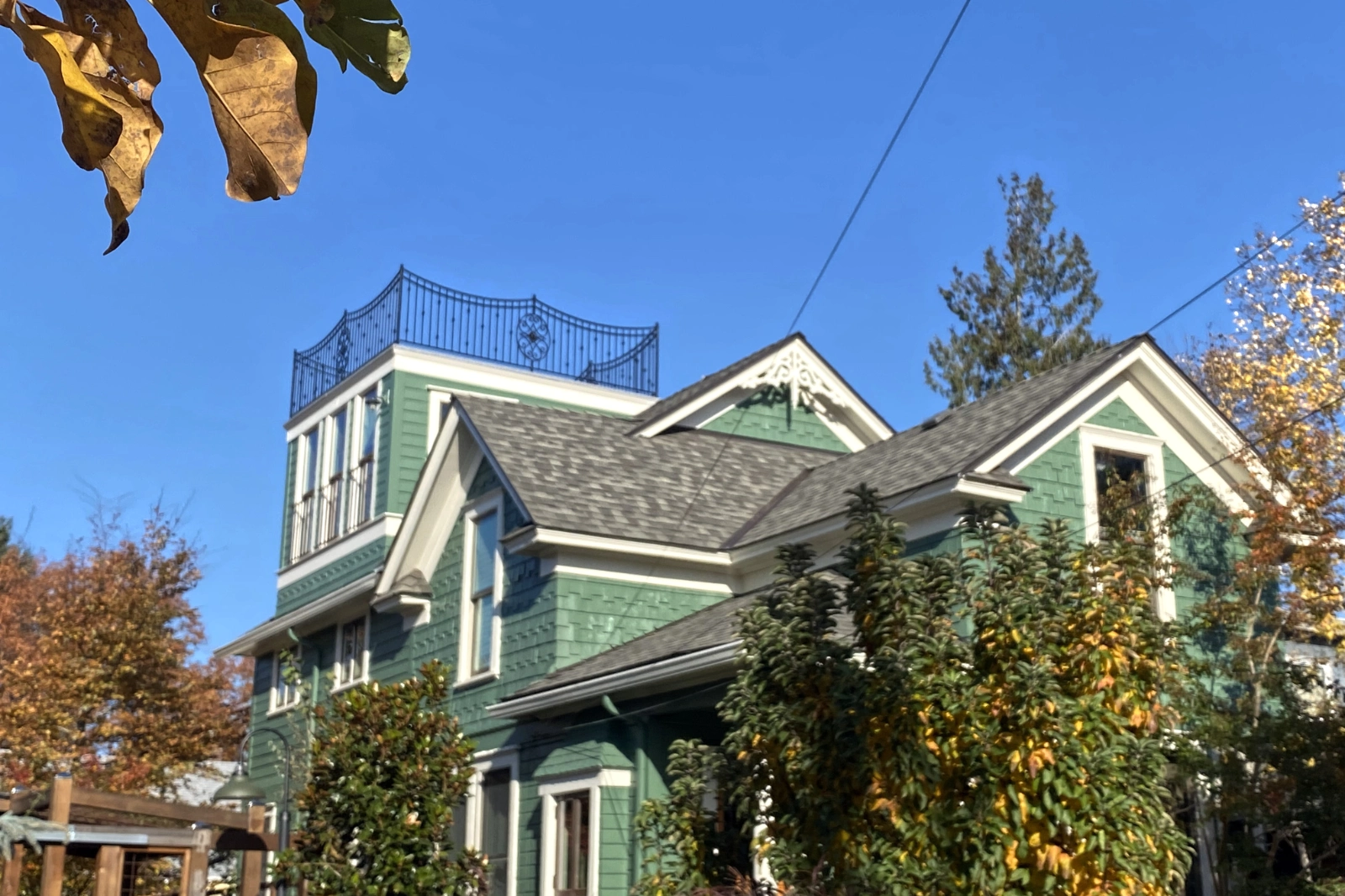A black wrought iron widow's walk railing with ornamental decorative scrolls, installed on the roof deck of Victorian home. | Chip and Dale's Iron Works