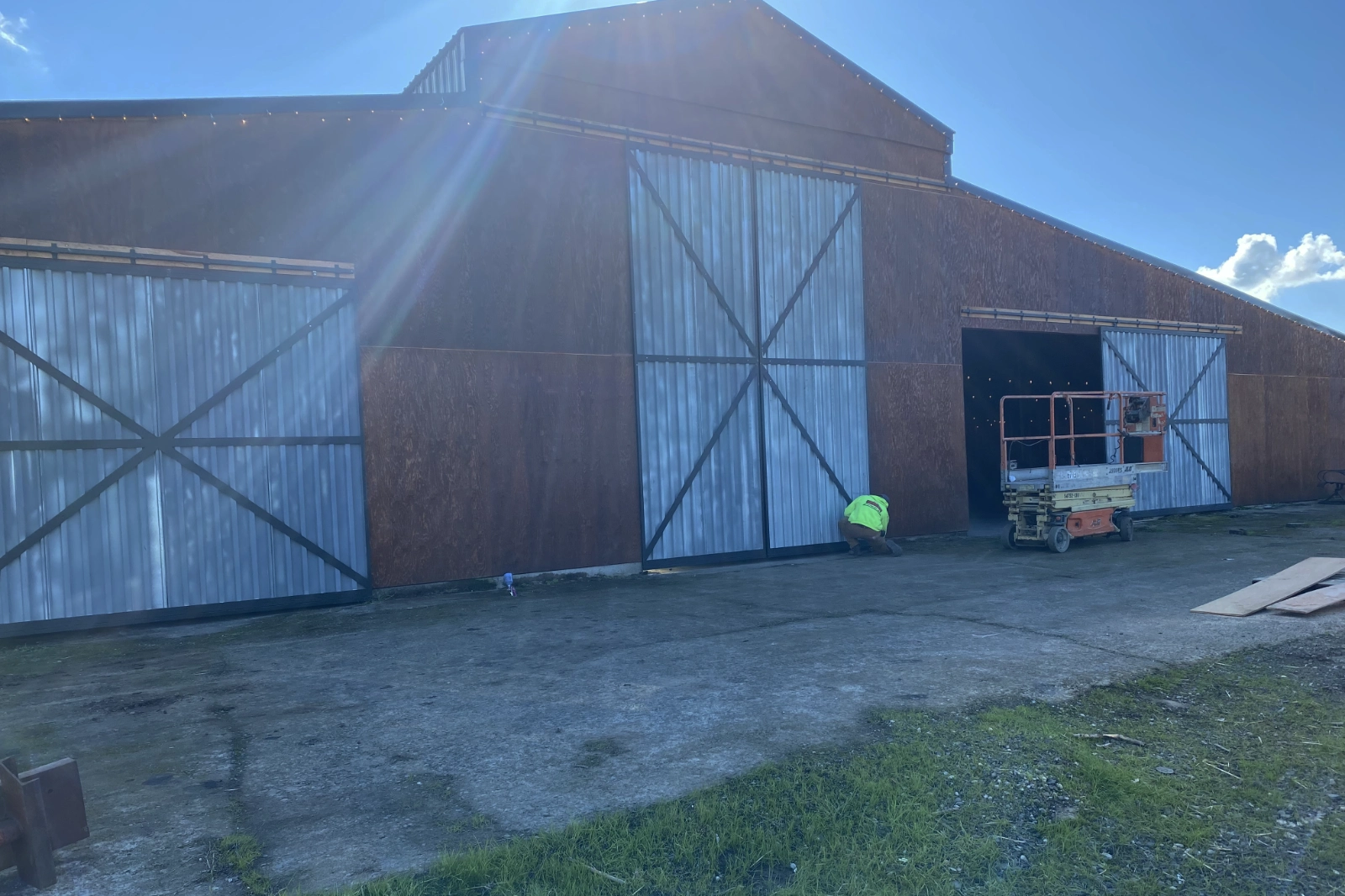 Large custom-fabricated corrugated metal sliding barn doors with black X-brace framing. | Chip and Dale's Iron Works